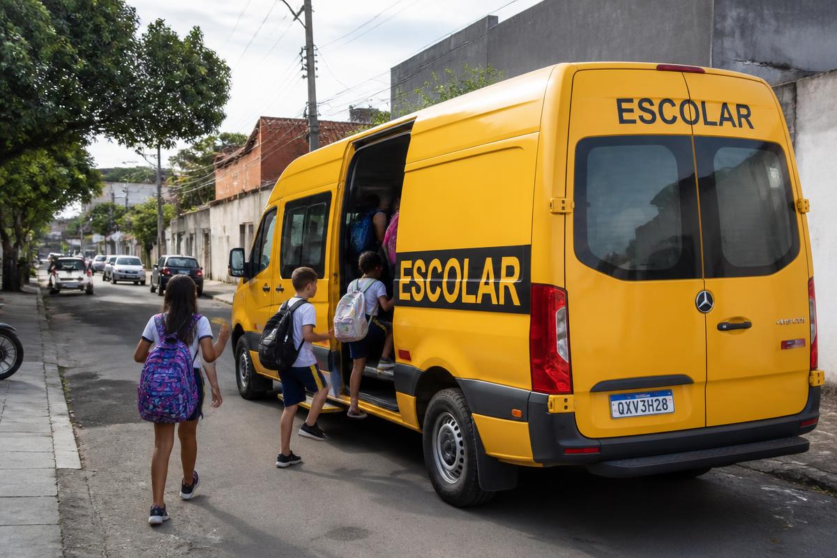 Van escolar amarela embarcando alunos em rua residencial
